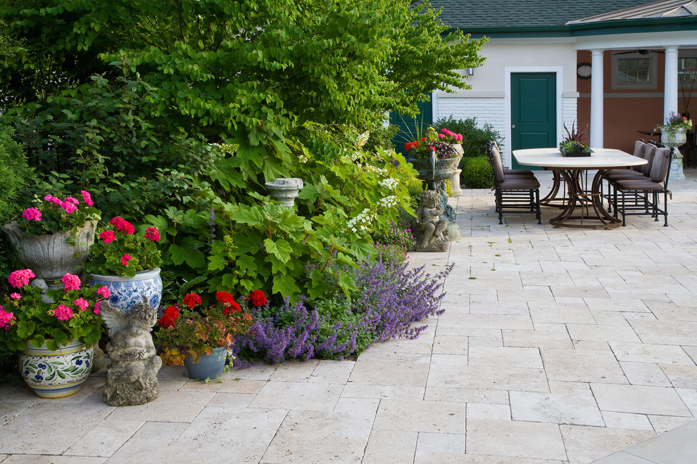 Idee per un grande patio o portico mediterraneo dietro casa con pavimentazioni in pietra naturale e un gazebo o capanno