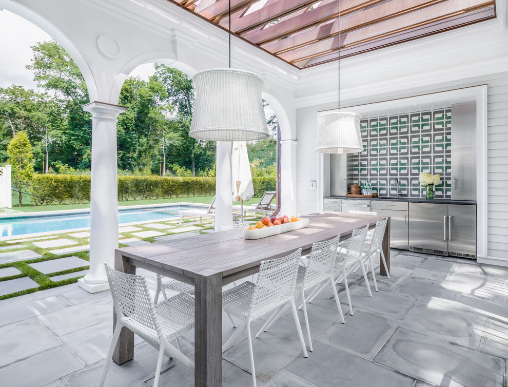 Beach style back patio in New York with an outdoor kitchen and a pergola.