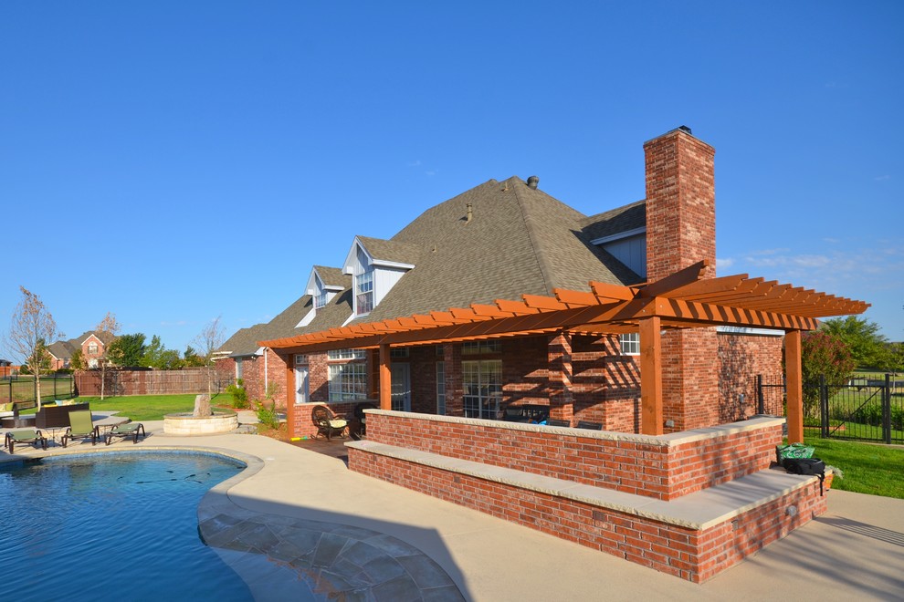 Foto di un patio o portico american style di medie dimensioni e dietro casa con lastre di cemento e una pergola