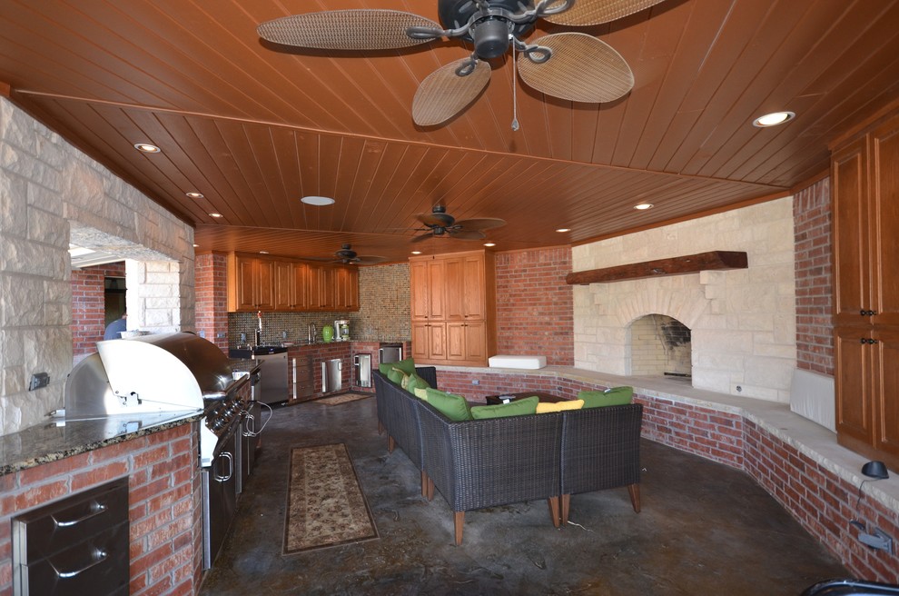 Modelo de patio de estilo americano de tamaño medio en patio trasero con cocina exterior, losas de hormigón y pérgola