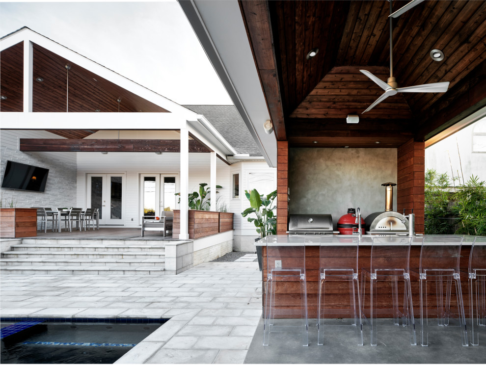 Patio kitchen - large modern backyard concrete paver patio kitchen idea in New Orleans with a gazebo