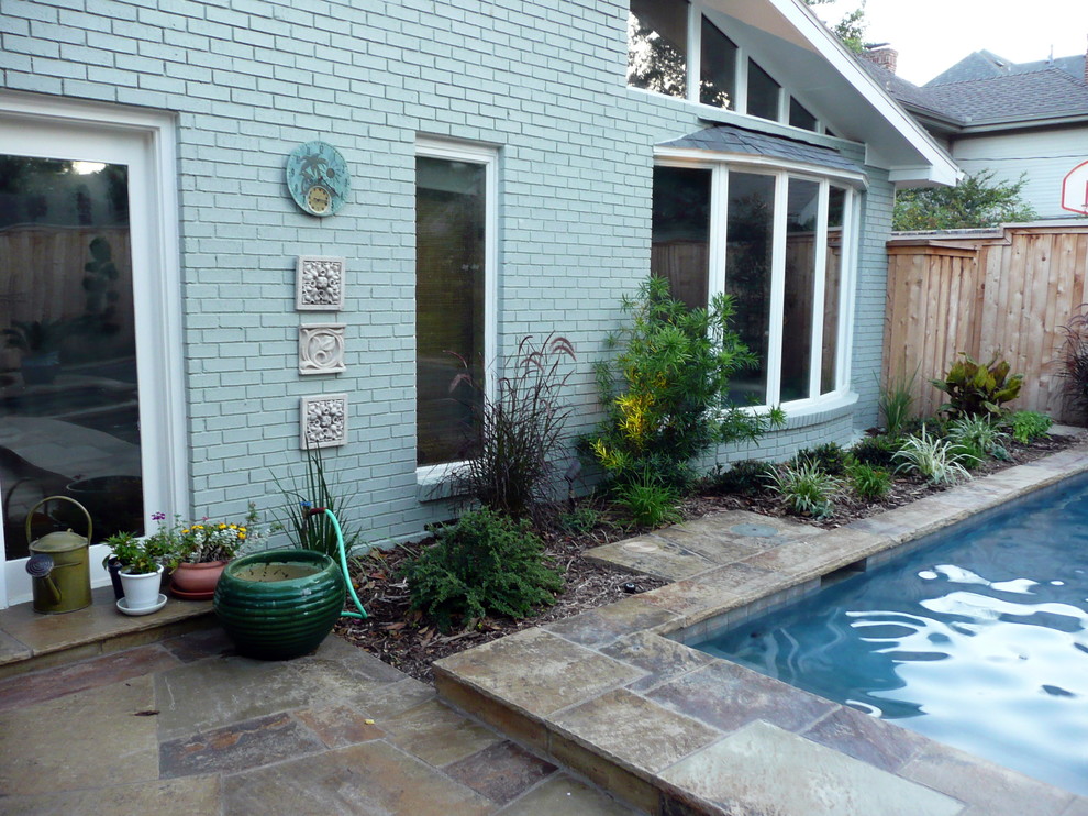 Contemporary back patio in Dallas with natural stone paving.