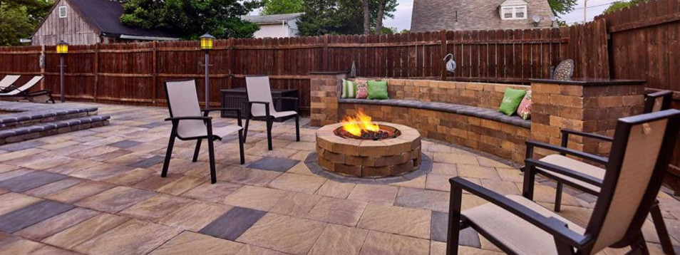 Imagen de patio clásico sin cubierta en patio trasero con brasero y adoquines de piedra natural