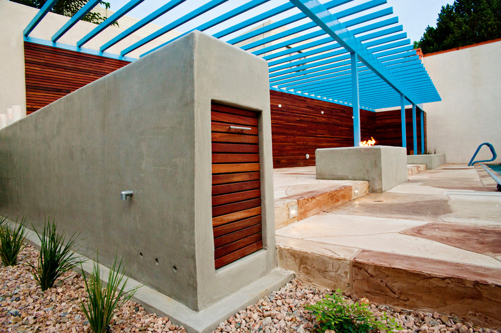 This is an example of a medium sized contemporary side patio in Albuquerque with stamped concrete and a pergola.