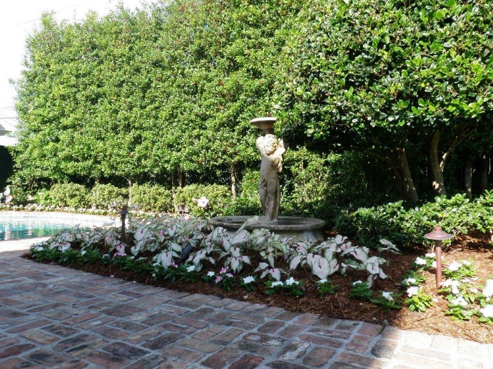 Mittelgroßer Klassischer Garten hinter dem Haus mit Wasserspiel und Pflastersteinen in New Orleans