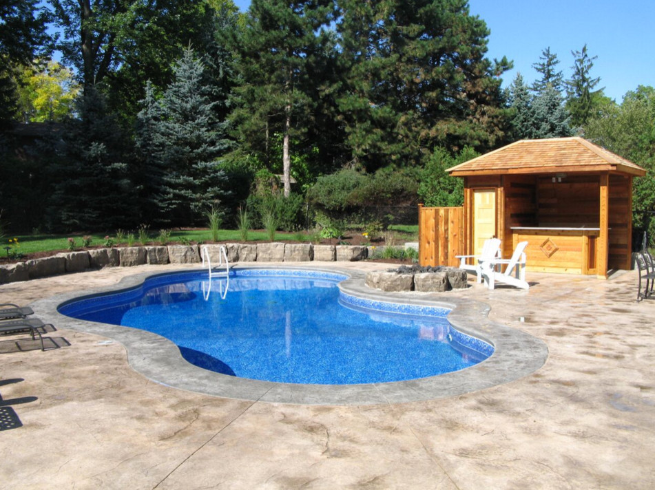 Idéer för att renovera en stor vintage pool på baksidan av huset, med stämplad betong