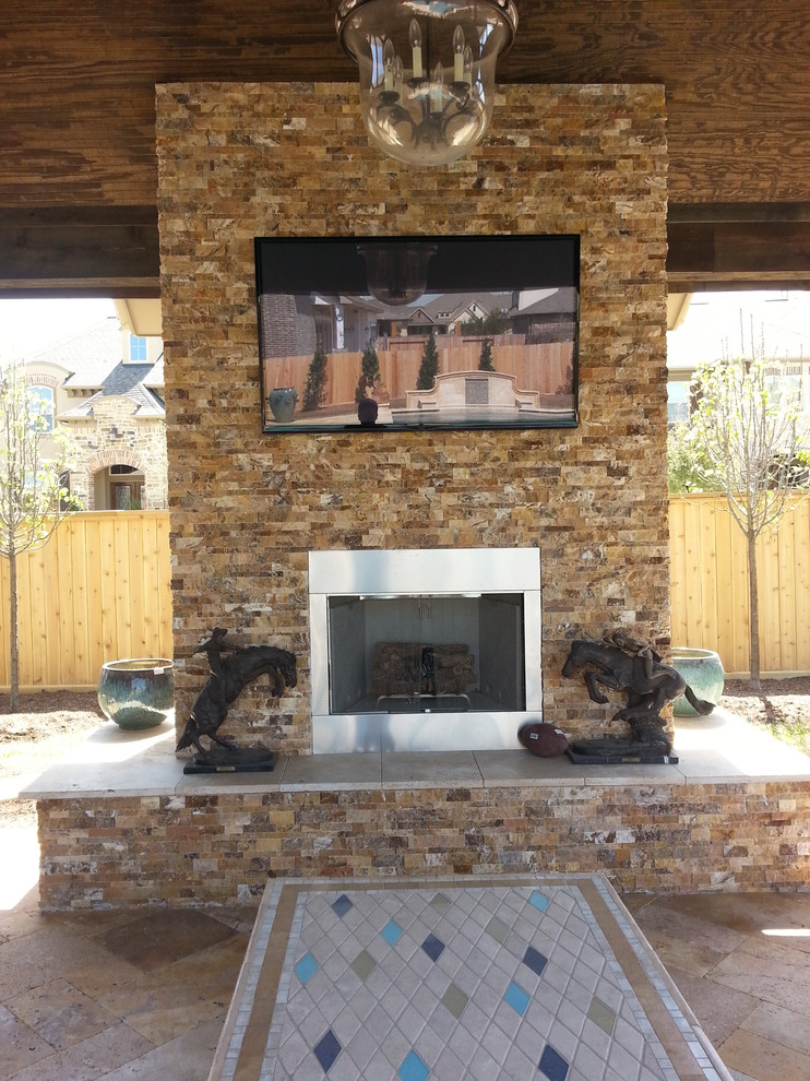 Photo of a large traditional back patio in Dallas with a fire feature, natural stone paving and a gazebo.