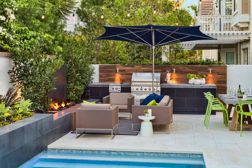 Photo of a small contemporary back patio in Los Angeles with a fire feature and natural stone paving.