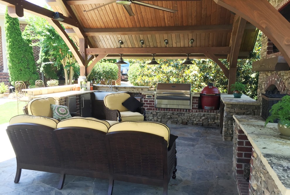 Réalisation d'une terrasse arrière chalet avec une cuisine d'été, une dalle de béton et un gazebo ou pavillon.