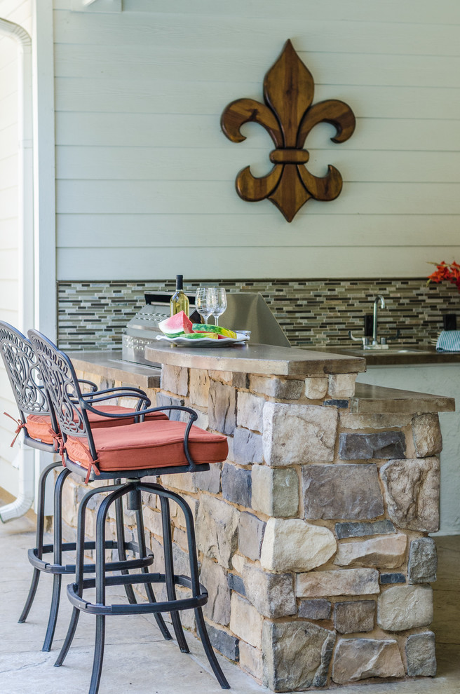 Überdachter Klassischer Patio hinter dem Haus mit Outdoor-Küche und Betonplatten in Dallas