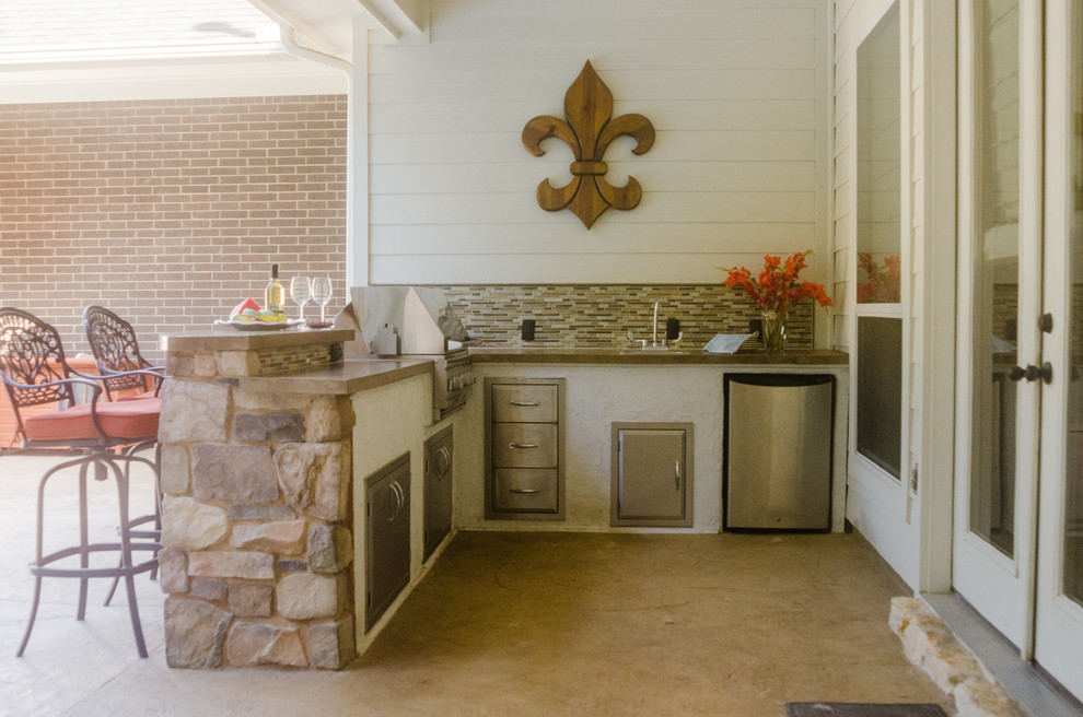 Cette photo montre une terrasse arrière chic avec une cuisine d'été, une dalle de béton et une extension de toiture.