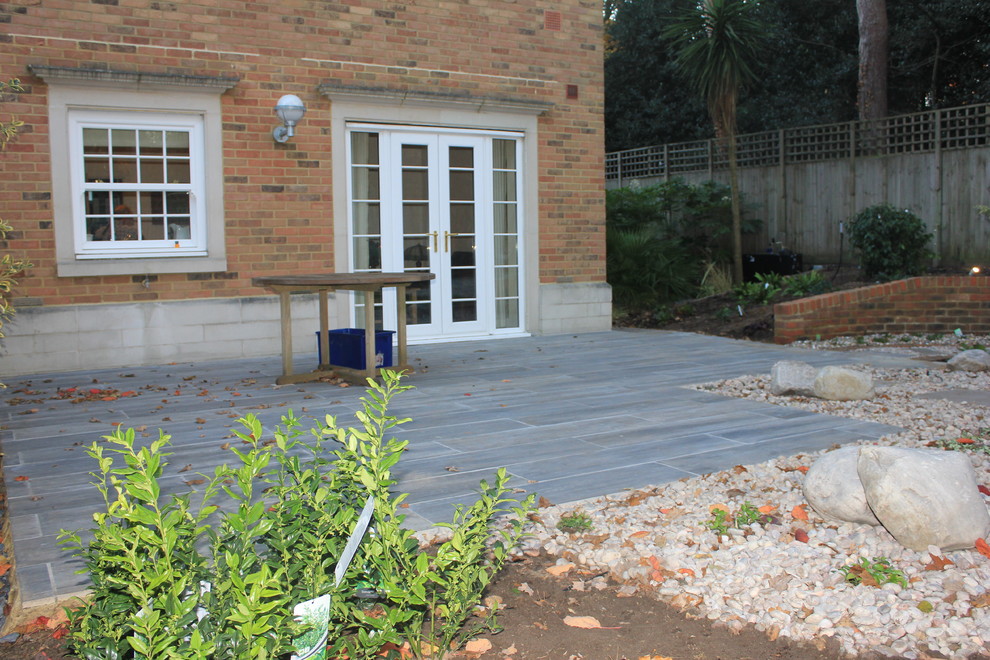 This is an example of a classic back patio in Surrey with natural stone paving.