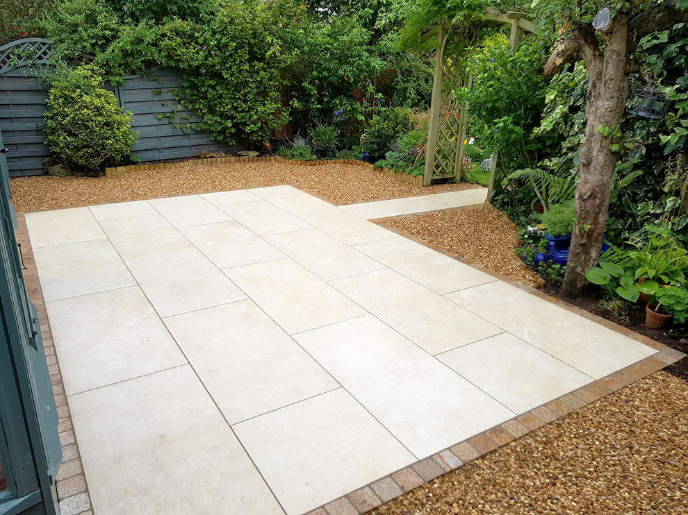 Design ideas for a medium sized modern back patio in Oxfordshire with tiled flooring and no cover.