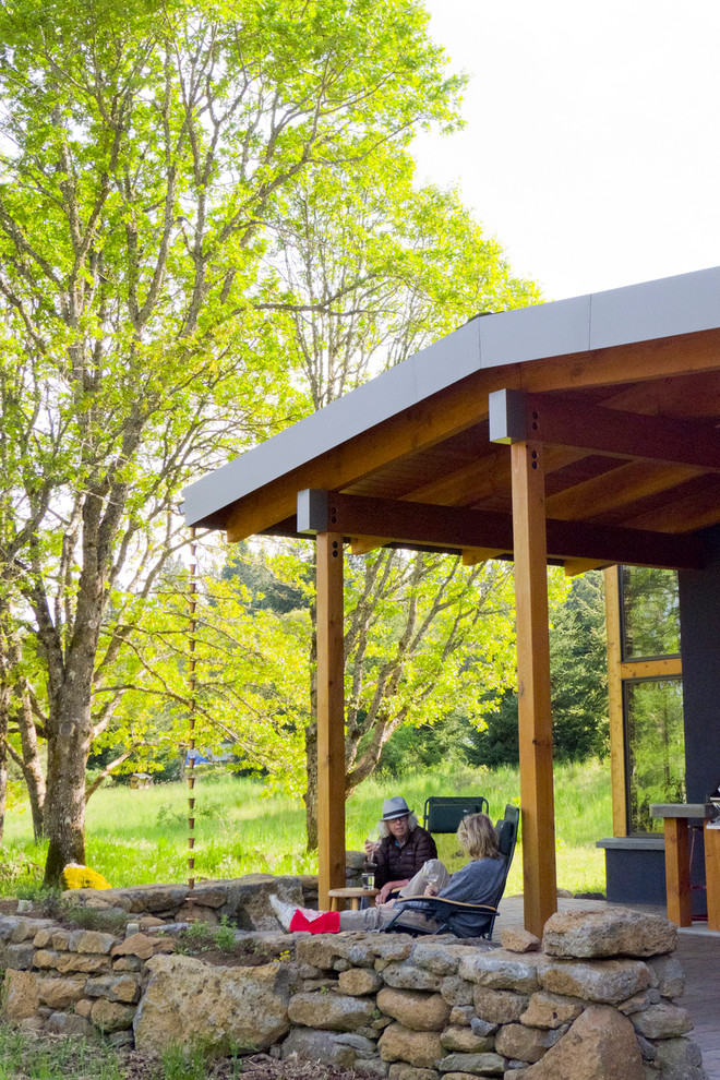 Idée de décoration pour une petite terrasse avant design avec une cuisine d'été, des pavés en brique et une extension de toiture.