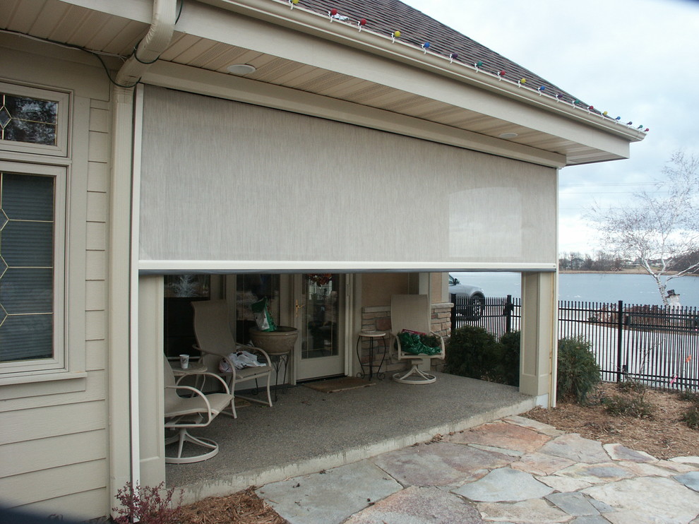Immagine di un piccolo patio o portico chic nel cortile laterale con pavimentazioni in pietra naturale e un tetto a sbalzo