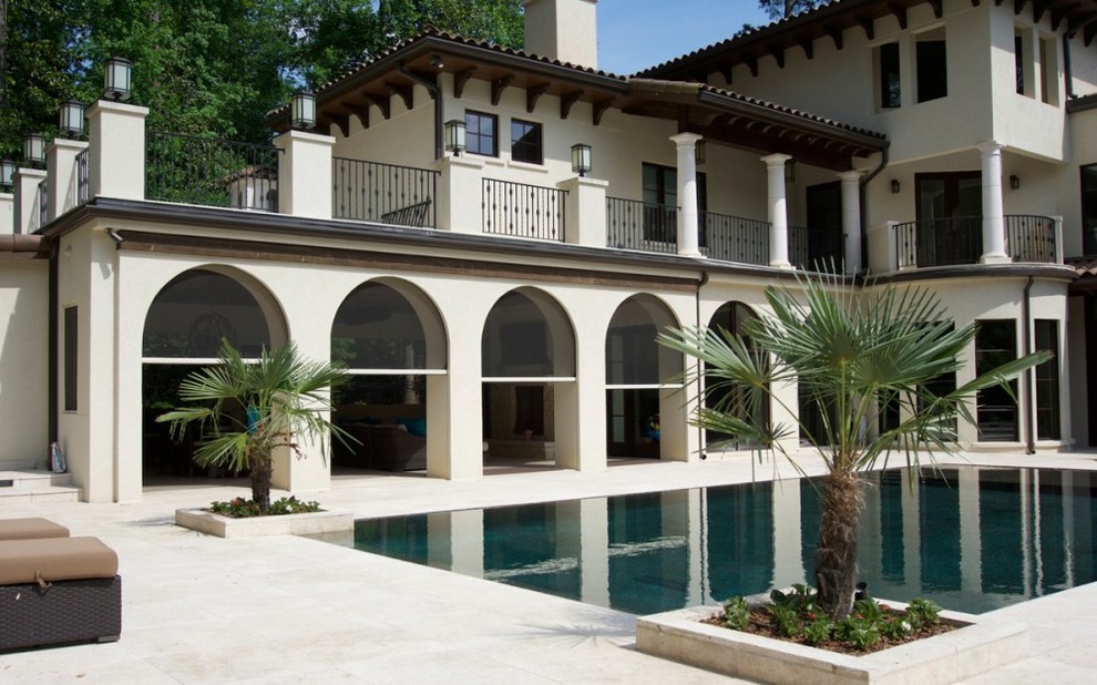 Exemple d'une grande terrasse arrière méditerranéenne avec des pavés en béton et une extension de toiture.