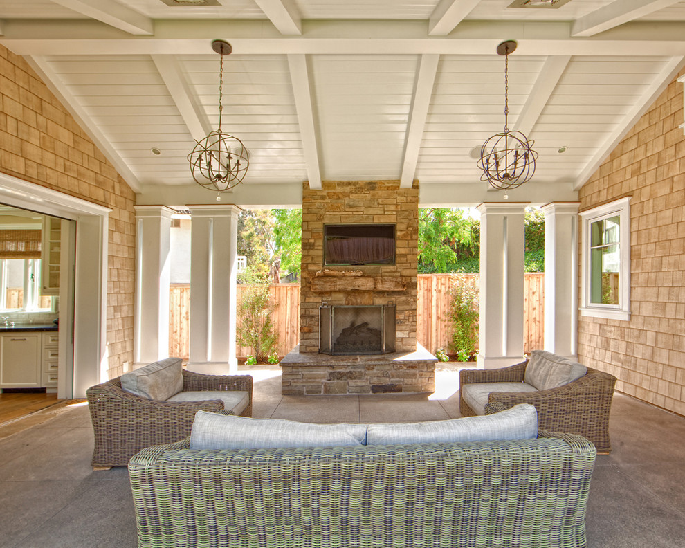 Example of a mid-sized classic courtyard concrete patio design in Orange County with a roof extension
