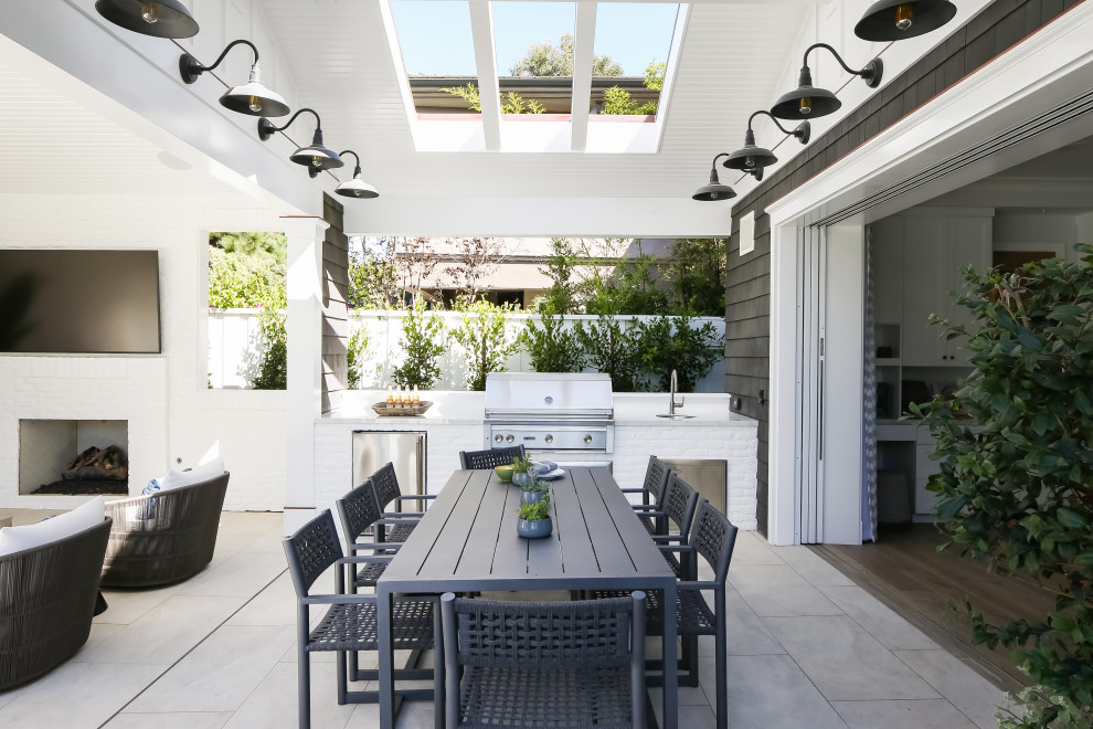 Стильный дизайн: двор среднего размера на заднем дворе в стиле неоклассика (современная классика) с летней кухней, покрытием из бетонных плит и навесом - последний тренд