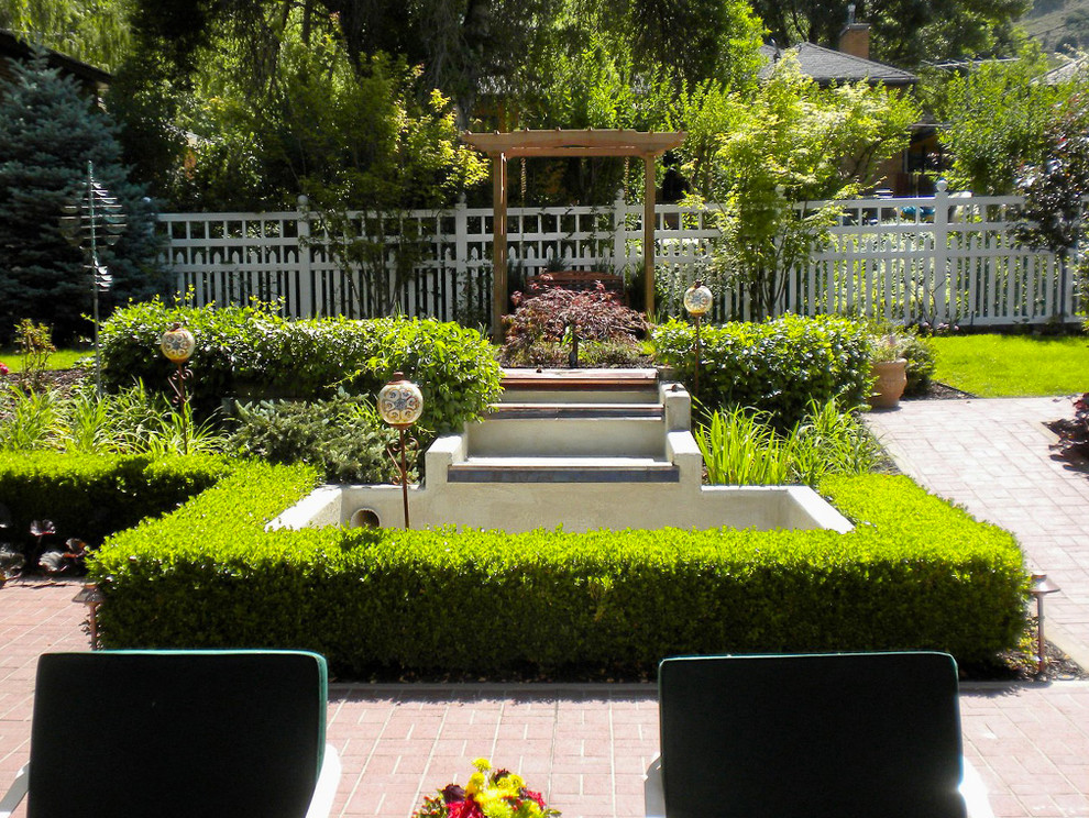 Foto di un giardino minimal di medie dimensioni e dietro casa con fontane e pavimentazioni in pietra naturale
