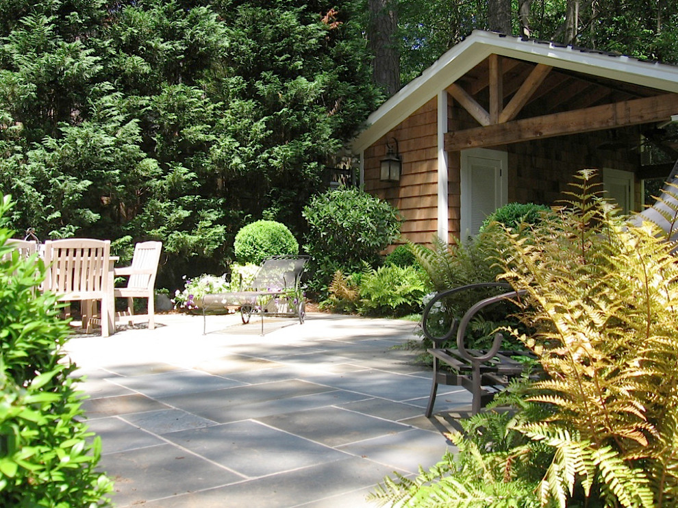 Foto di un patio o portico classico di medie dimensioni e dietro casa con un gazebo o capanno e pavimentazioni in pietra naturale