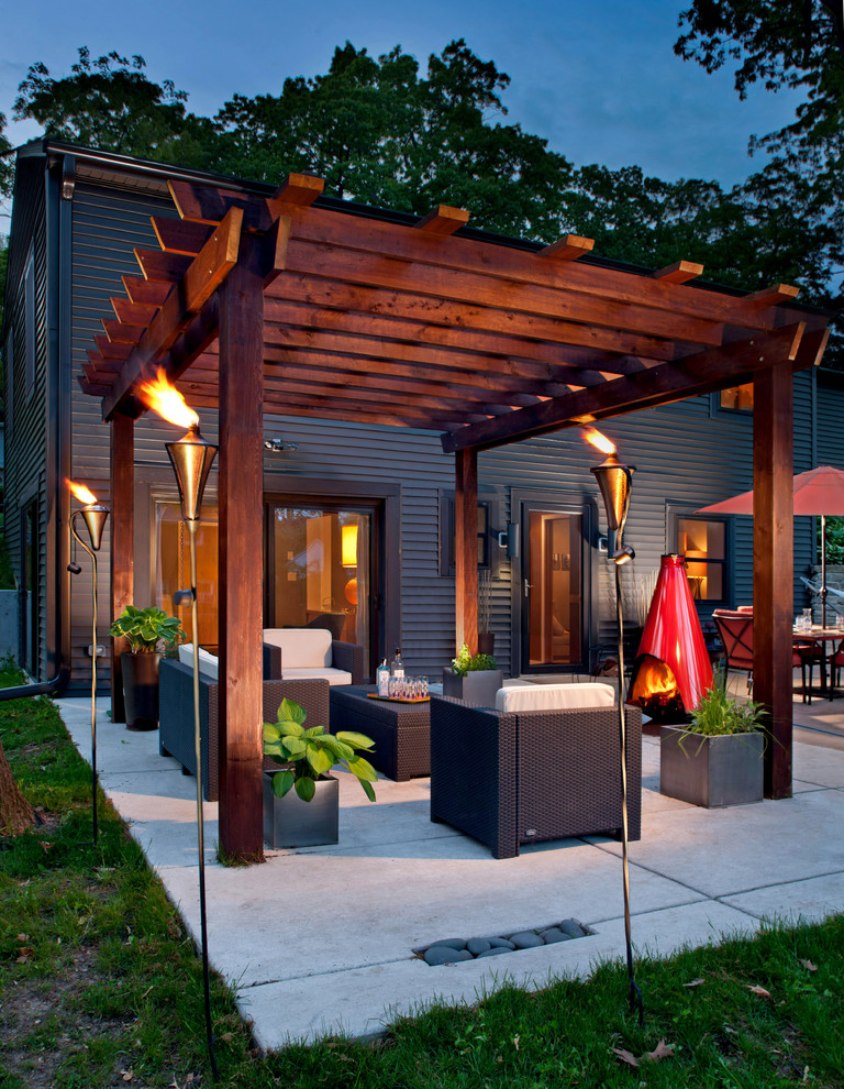 Inspiration for a mid-sized contemporary backyard concrete patio remodel in Milwaukee with a fire pit and a pergola