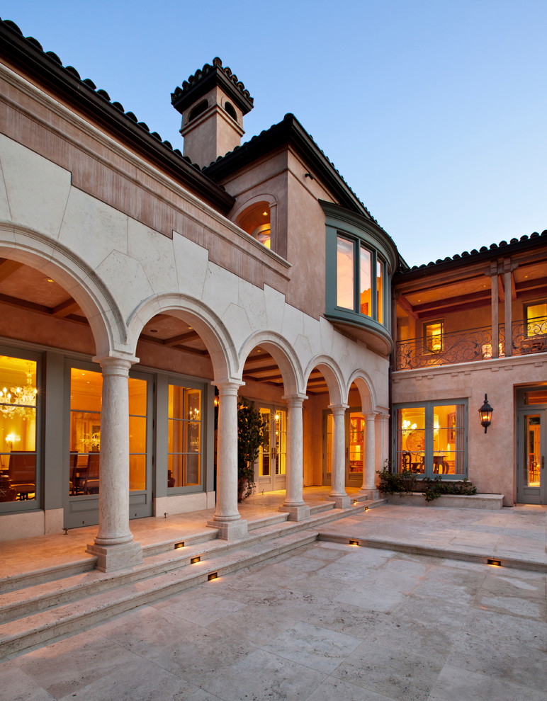 Photo of an expansive mediterranean back patio in San Francisco with natural stone paving and a roof extension.