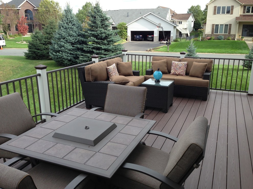 This is an example of a small traditional side patio in Minneapolis with a fire feature, decking and no cover.