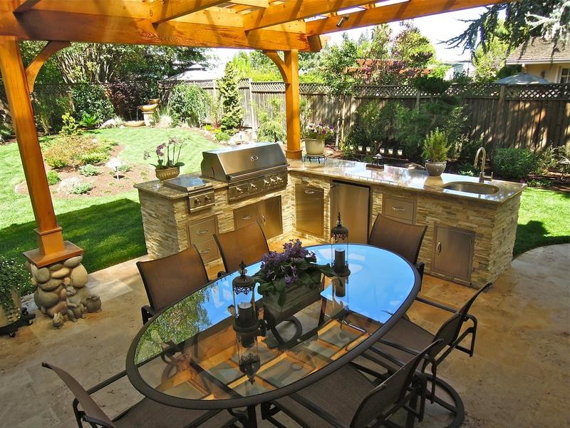 Diseño de patio tradicional de tamaño medio en patio trasero con cocina exterior, suelo de hormigón estampado y pérgola