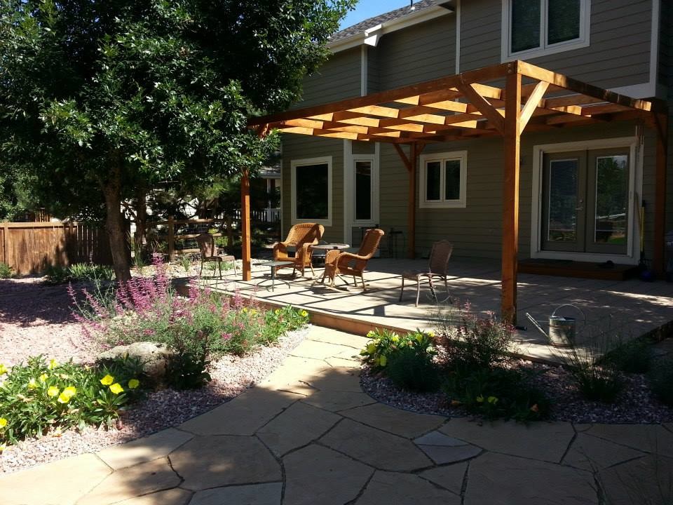 Immagine di un patio o portico di medie dimensioni e dietro casa con un giardino in vaso, pavimentazioni in pietra naturale e una pergola