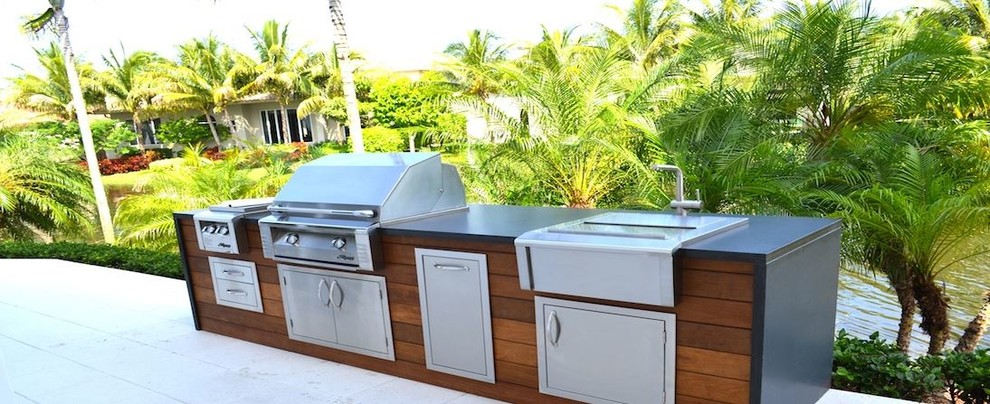 Photo of a large contemporary back patio in Tampa with an outdoor kitchen, stamped concrete and a roof extension.