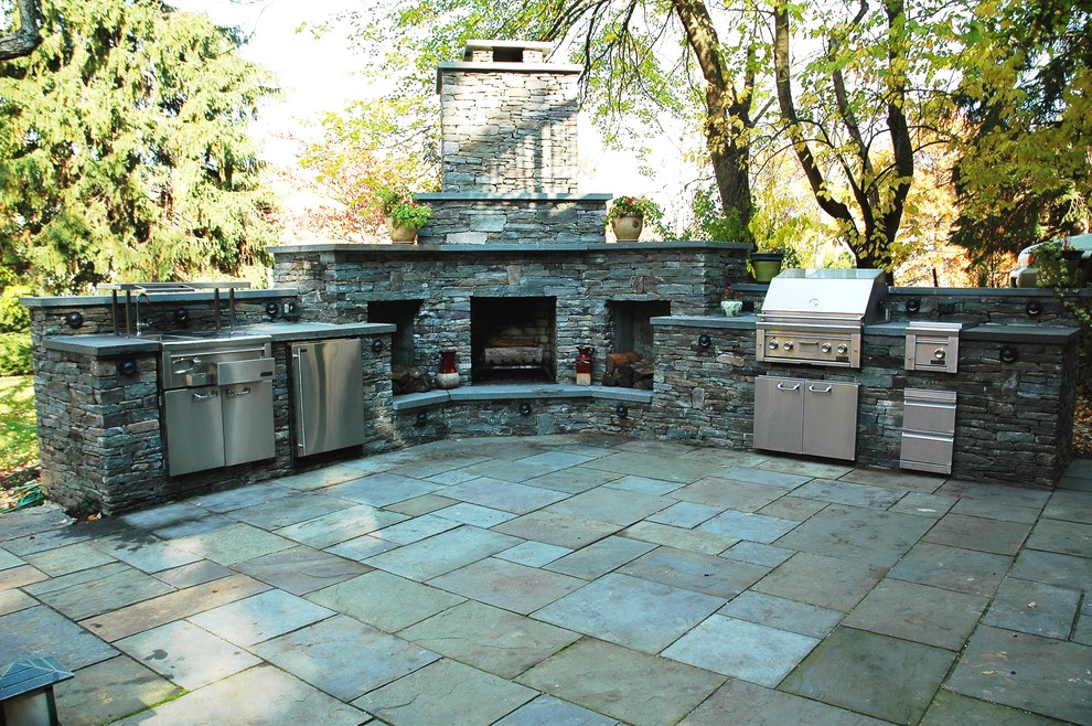 Exemple d'une grande terrasse arrière tendance avec une cuisine d'été, du béton estampé et une extension de toiture.
