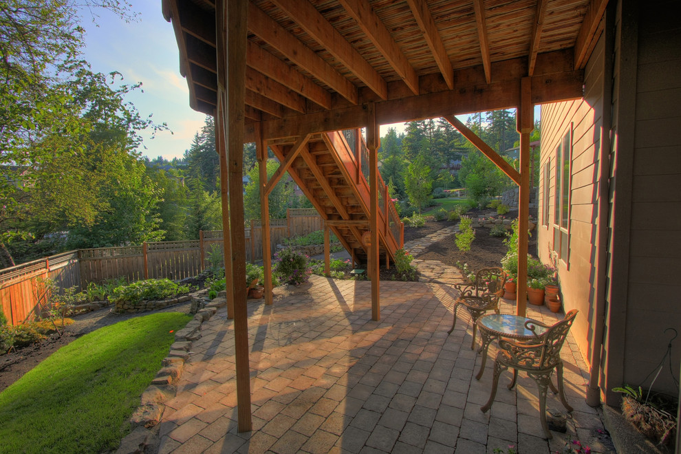 Cette photo montre une terrasse chic avec des pavés en béton et une extension de toiture.