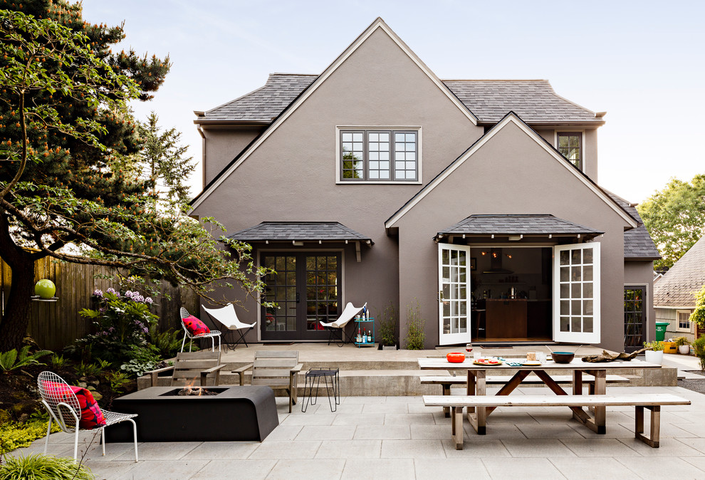 Exemple d'une terrasse arrière tendance de taille moyenne avec un foyer extérieur et des pavés en béton.