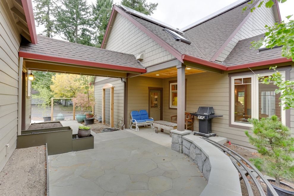 Esempio di un patio o portico stile americano in cortile con lastre di cemento e un tetto a sbalzo