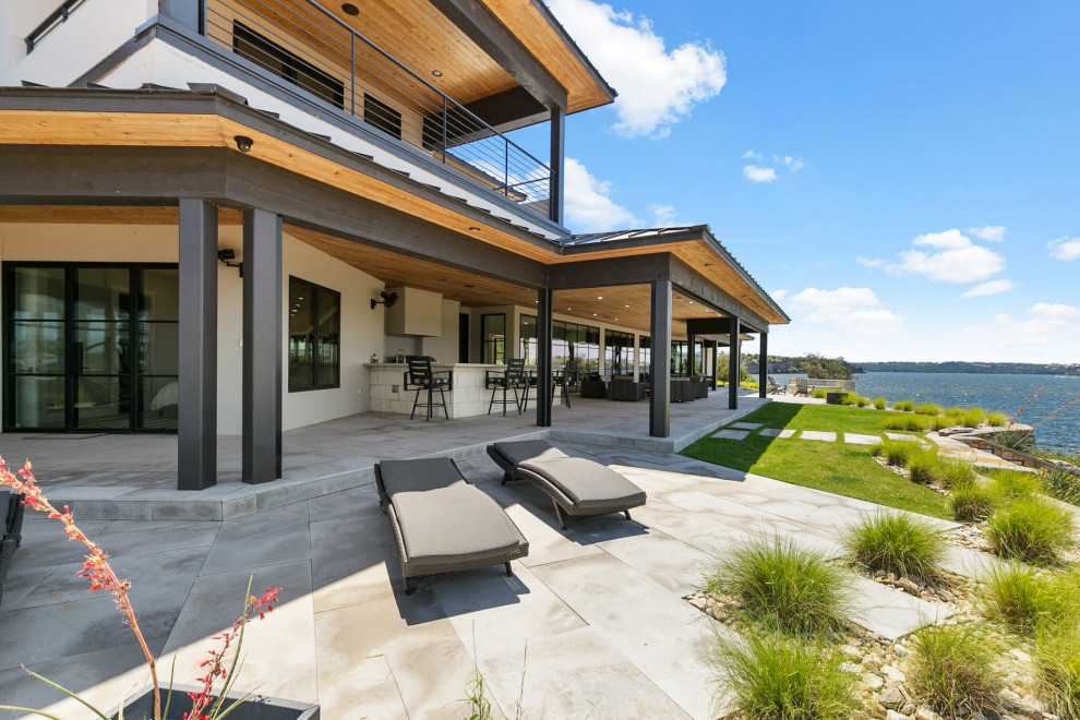 Patio kitchen - coastal backyard concrete paver patio kitchen idea in Dallas with a roof extension