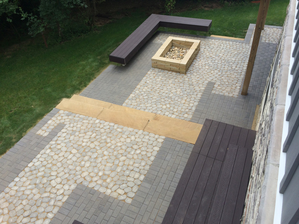 Foto di un patio o portico minimalista di medie dimensioni e dietro casa con un focolare e pavimentazioni in cemento