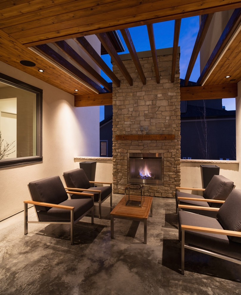 Geräumige Moderne Pergola neben dem Haus mit Feuerstelle und Betonplatten in Calgary