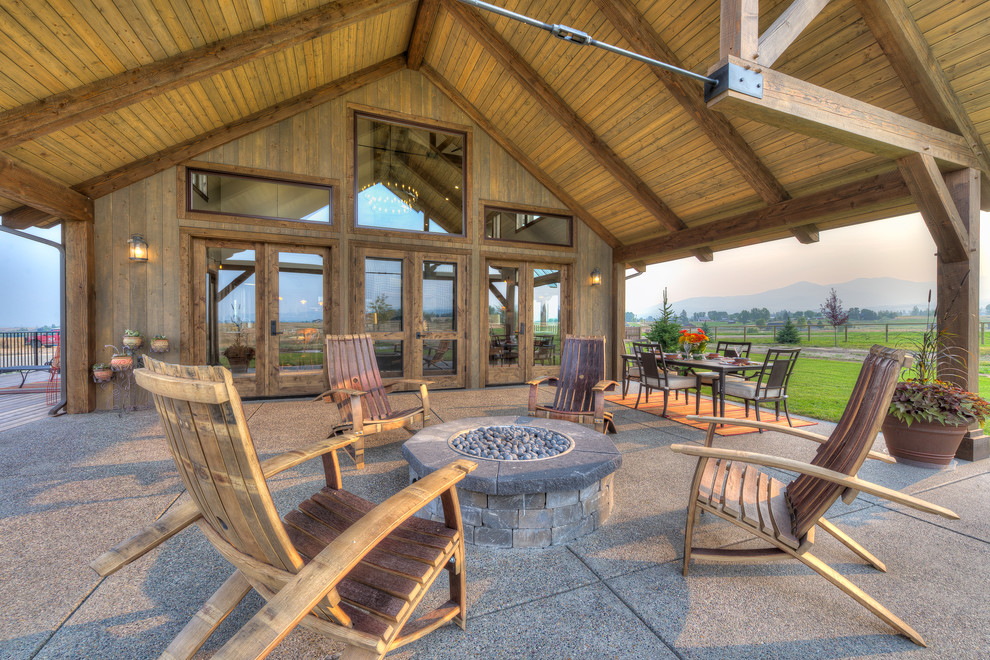 Mountain style backyard patio photo in Other with a fire pit and a roof extension