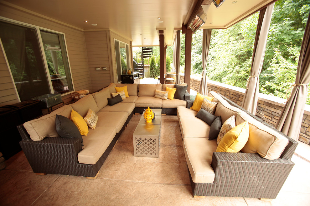 Photo of a large modern back patio in Seattle with a fireplace, stamped concrete and a roof extension.