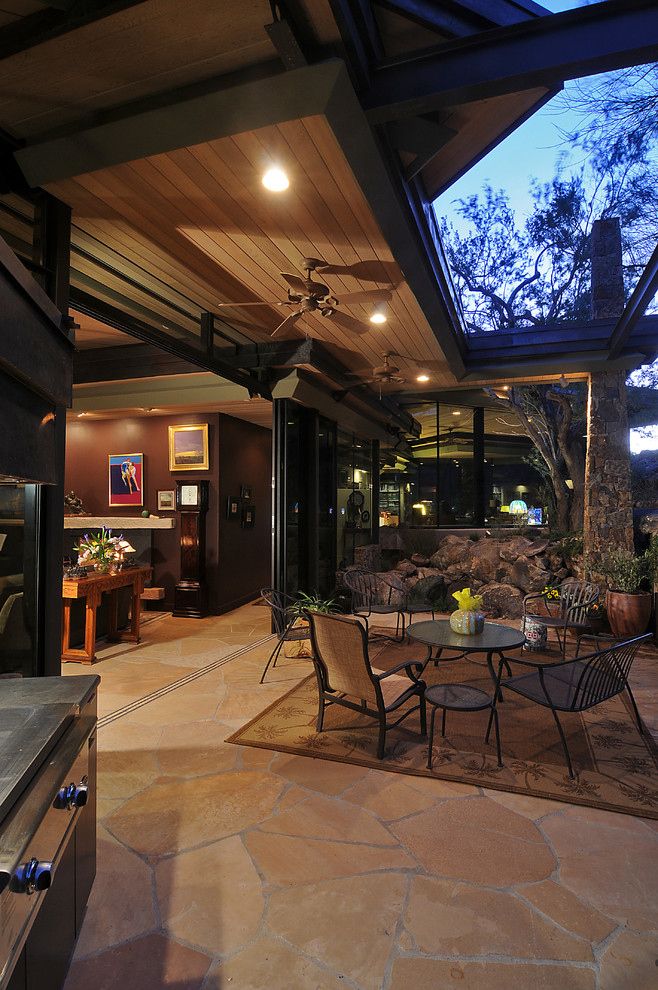 На фото: двор среднего размера на заднем дворе в современном стиле с местом для костра, покрытием из каменной брусчатки и навесом с