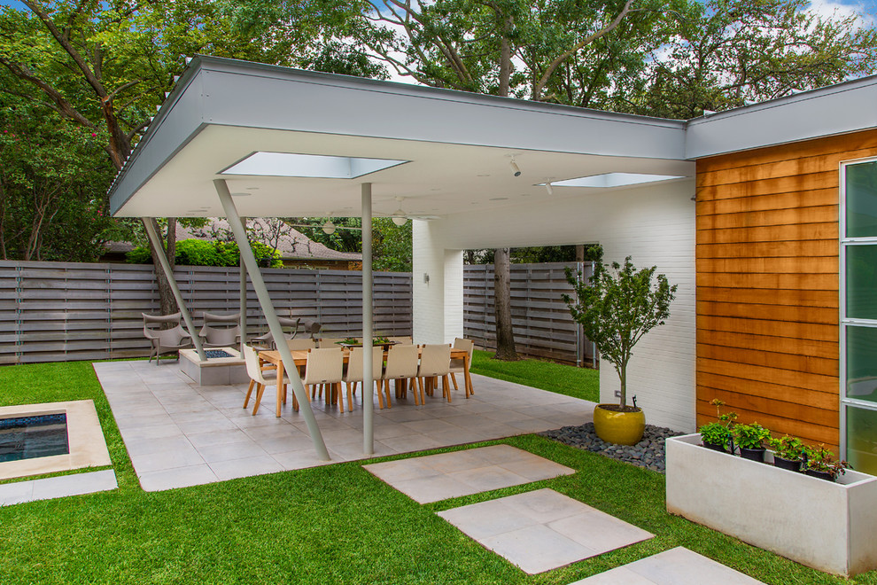 Aménagement d'une grande terrasse arrière moderne avec un foyer extérieur, du carrelage et un gazebo ou pavillon.