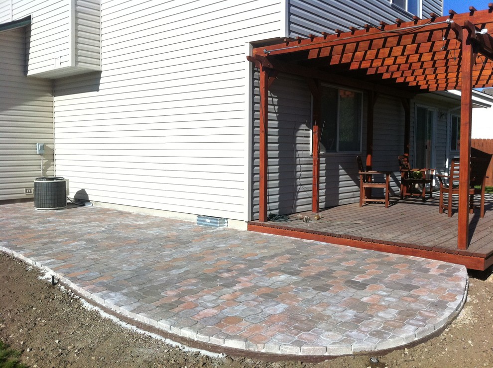 Design ideas for a large traditional back patio in Boise with an awning and brick paving.