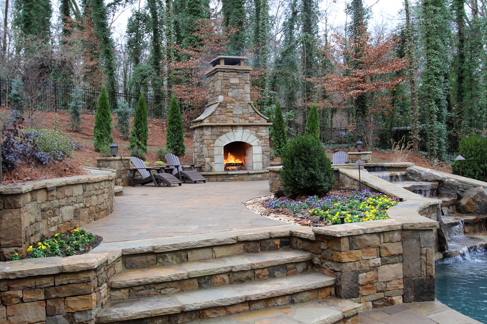 This is an example of a large modern back patio in Atlanta with a fire feature, concrete paving and no cover.