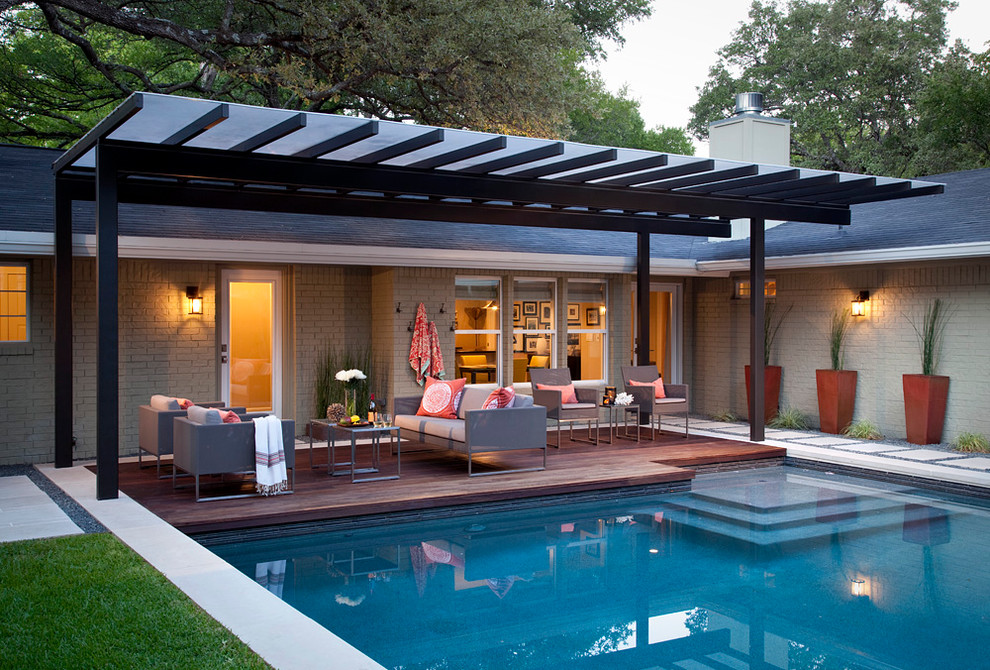 Immagine di un patio o portico minimalista di medie dimensioni e dietro casa con pedane e una pergola