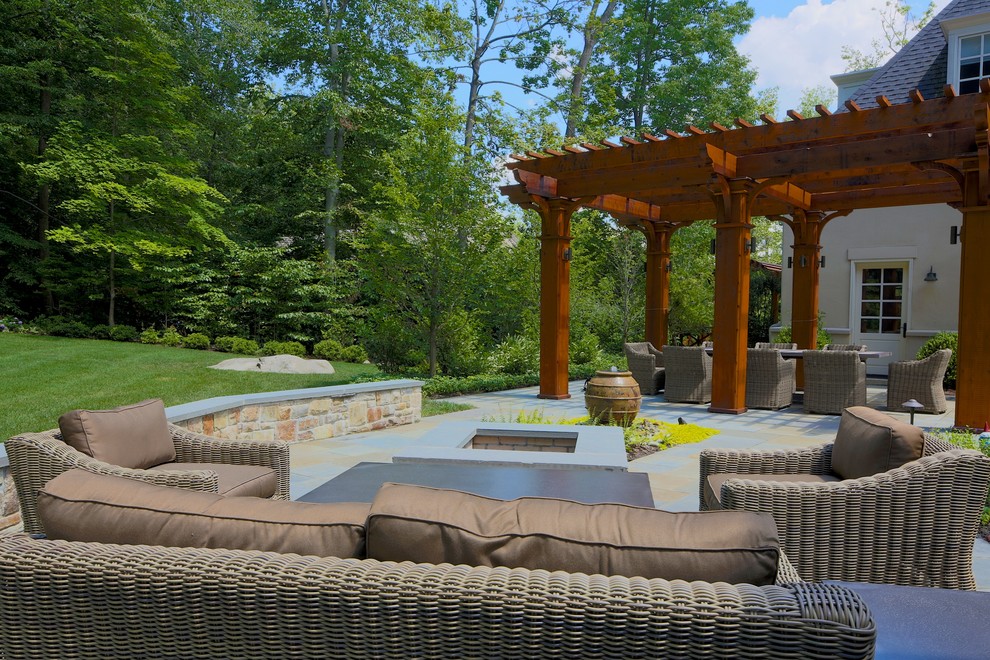 Idées déco pour une grande terrasse arrière classique avec une cuisine d'été, des pavés en pierre naturelle et une pergola.