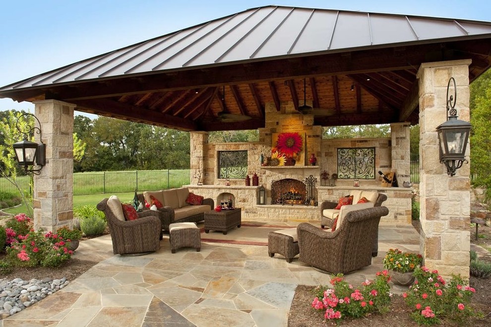 Cette image montre une grande terrasse arrière traditionnelle avec un foyer extérieur, des pavés en pierre naturelle et un gazebo ou pavillon.
