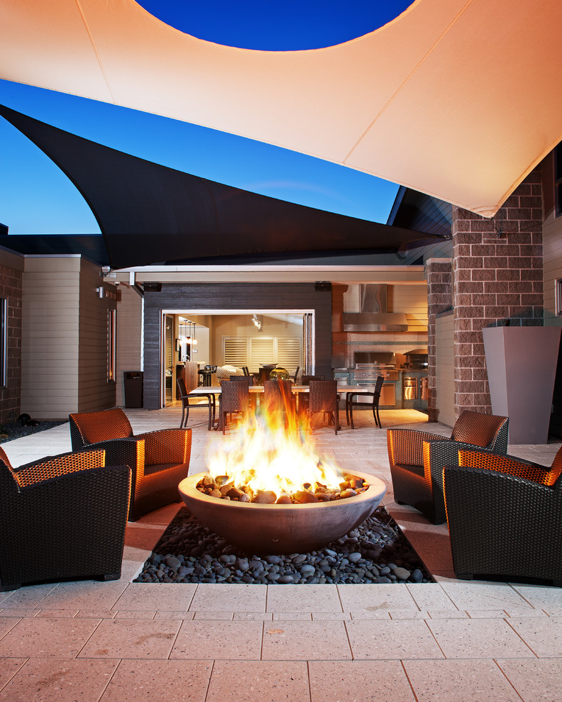 Patio - transitional concrete paver patio idea in Omaha with a fire pit and an awning