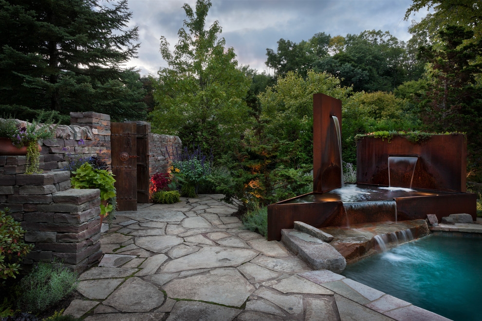 Diseño de patio minimalista de tamaño medio sin cubierta en patio trasero con fuente y adoquines de piedra natural