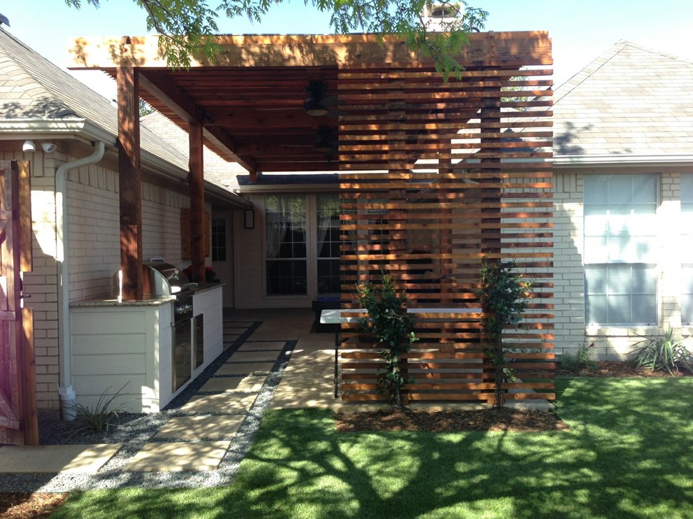 Esempio di un piccolo patio o portico moderno dietro casa con un focolare, lastre di cemento e una pergola