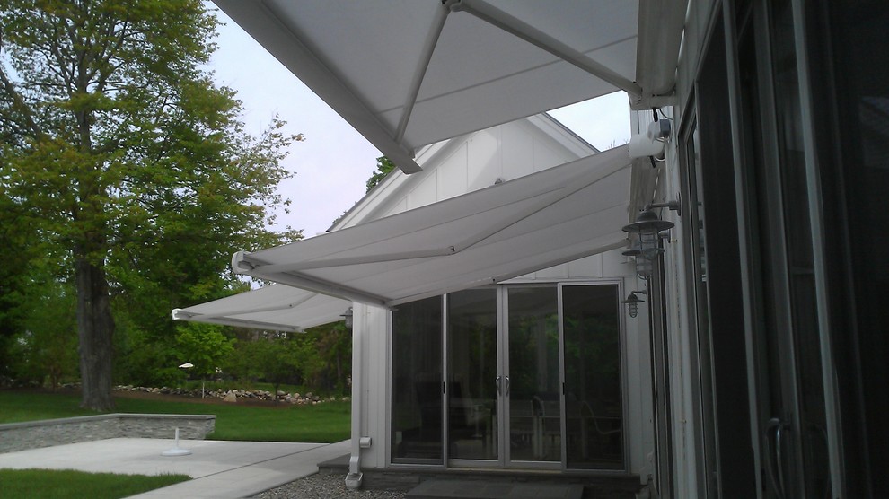 Idee per un patio o portico minimal di medie dimensioni e dietro casa con pavimentazioni in pietra naturale e un parasole